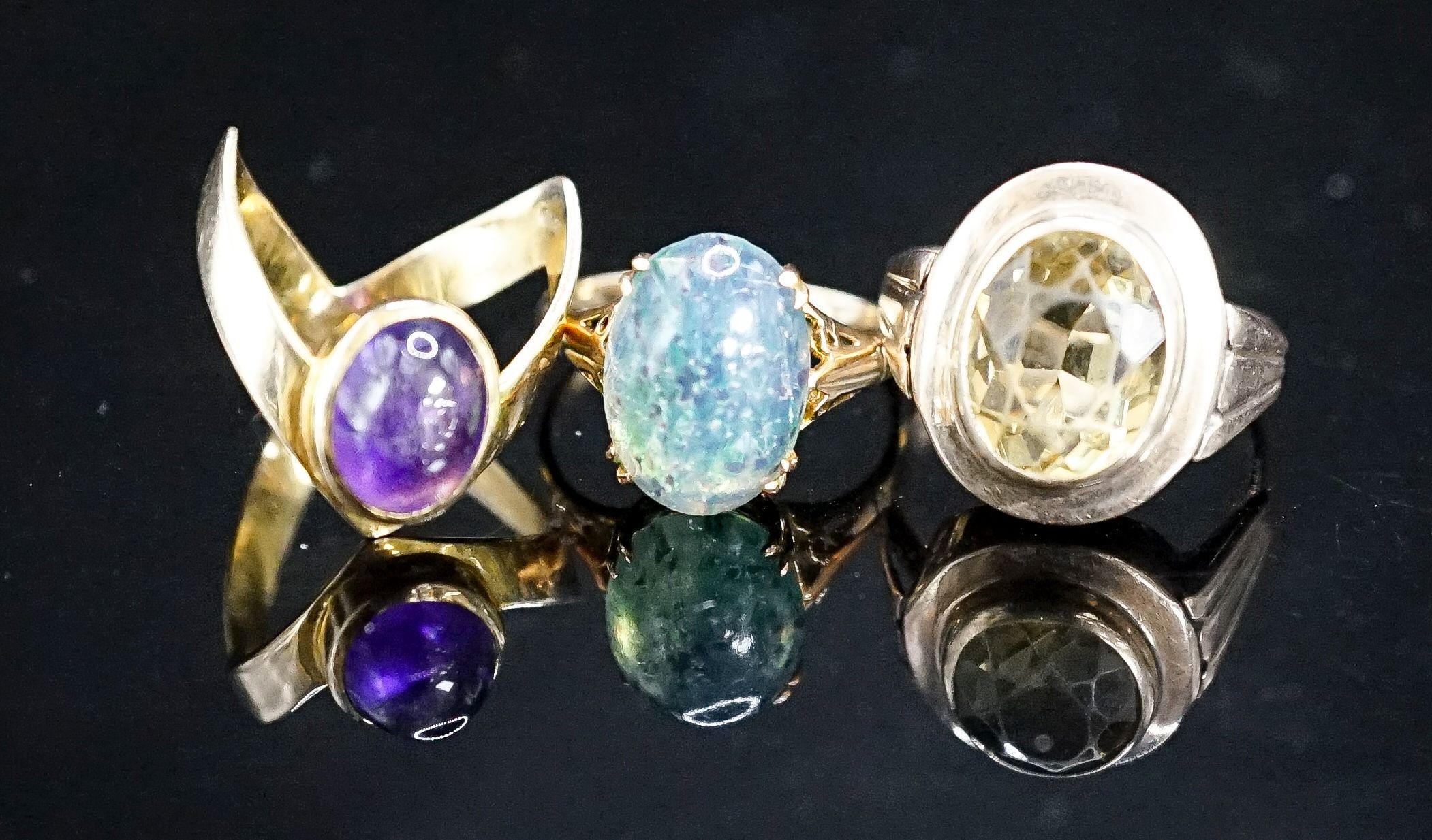 Two 9ct and gem set dress rings, gross 6.8 grams and a 333(8ct) and gem set dress ring, gross 5.6 grams.